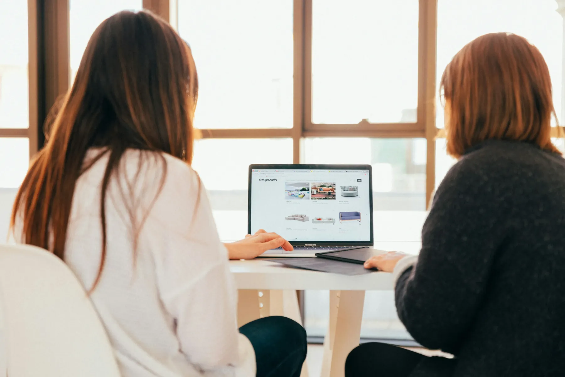 Deux personnes consultant un site internet sur un ordinateur portable